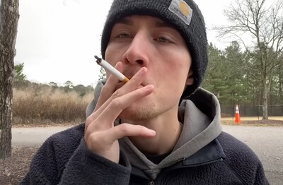 Лечение зависимости от табакокурения в Змеиногорске Мужчина с сигаретой делает затяжку